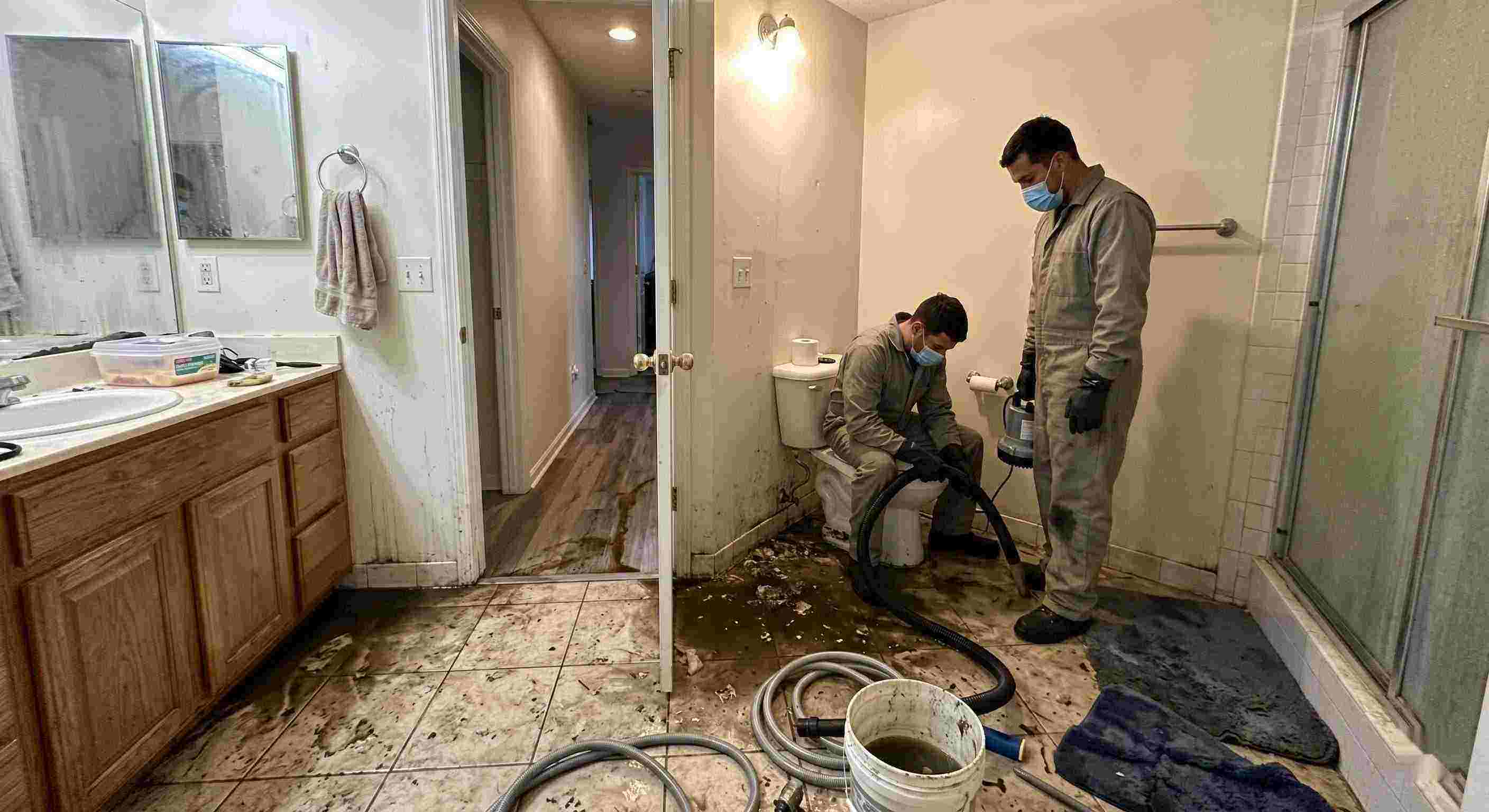 Septic tank backup cleanup in Rochester bathroom with technicians removing contaminated water and sanitizing affected areas