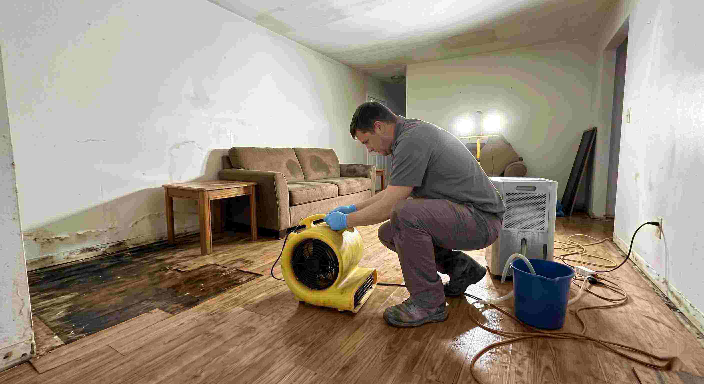 Fast water damage restoration technician drying wet floors with equipment during cleanup process in Batavia